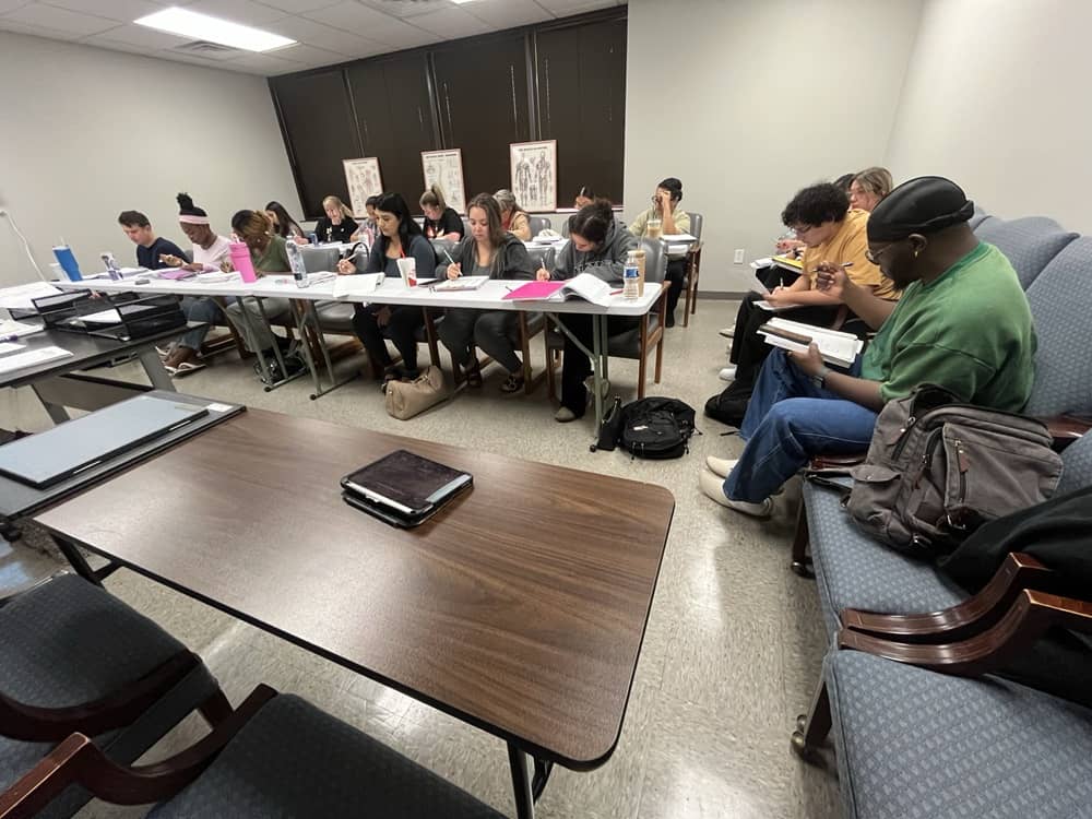 Student reviewing course materials beside imaging equipment