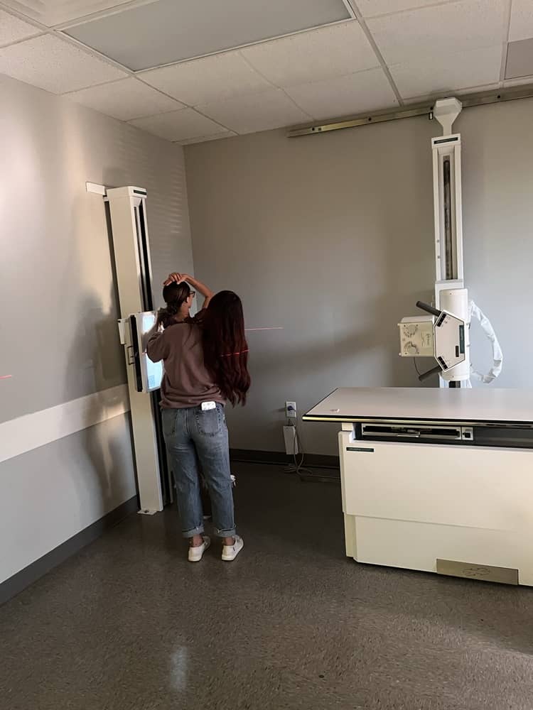 Student positioning an imaging receptor beneath the table