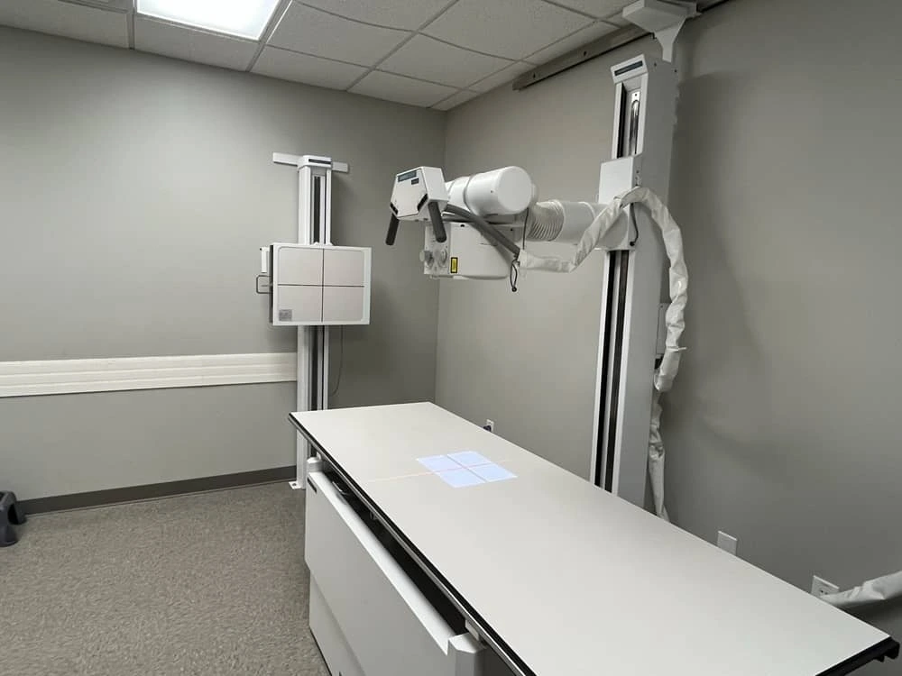 Student adjusting portable X-ray equipment during lab practice